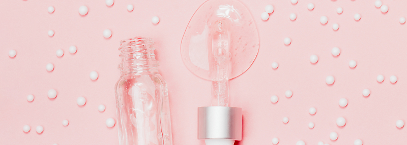 image of pipette dropping hyaluronic acid onto pink background