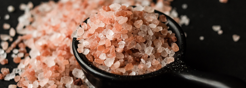 image of pink salt in black bowl