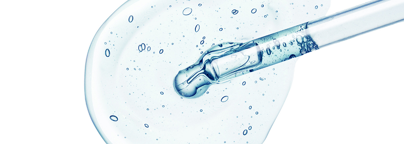 image of pipette dropping liquid on to white background